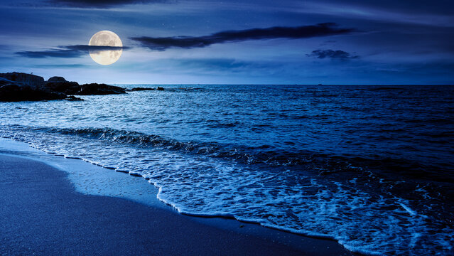 panoramic view of sand beach landscape at night. summer vacation season at the black sea in full moon light. beautiful seaside with calm water. wide coast travel banner