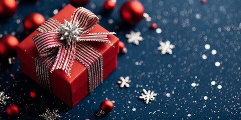 Obraz premium Red Christmas gift box with silver and red striped ribbon and bow on a dark blue background with ornaments and snowflakes