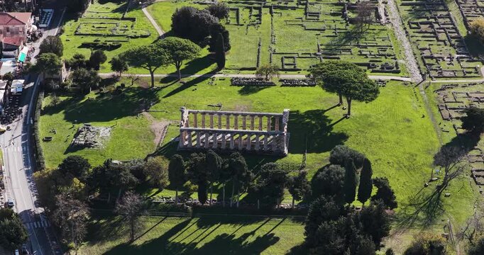 Aerial view of the Temple of Hera I, a symphony of ancient stones and verdant lawns, bathed in the golden Italian sun, Paestum, Campania, Italy.