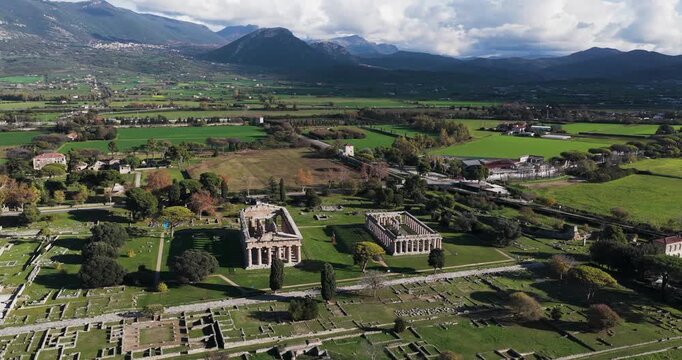 Aerial view of the Paestum temples, standing as ancient monuments amidst the sprawling green landscape, a testament to time, Paestum, Campania, Italy.
