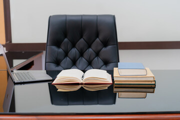 Books were arranged on the executive's desk, with a laptop beside it.