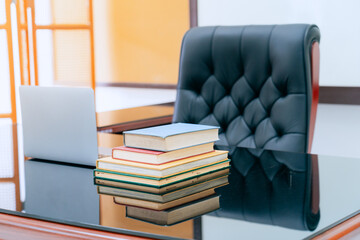 Books were arranged on the executive's desk, with a laptop beside it.