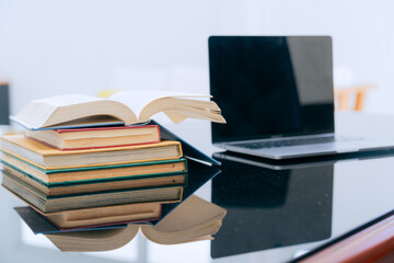 Books were arranged on the executive's desk, with a laptop beside it.