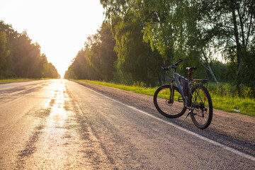 Fototapeta premium Road bike handlebar at sunny road. Riding a bicycle on empty highway. Bicycle handlebar . High quality photo
