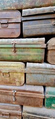 ollection of Aged and Corroded Iron Suitcases Stacked Neatly to Form a Decorative Background, Emphasizing the Patina, Rustic Colours, and Historical Aesthetic of Old Travel Gear