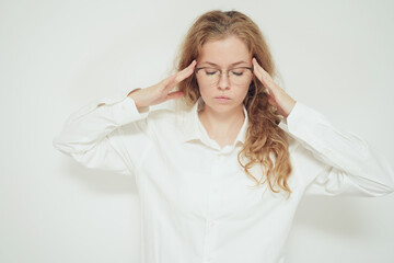 Fototapeta premium Young woman in glasses touching her temples with eyes closed, concentrating on a difficult task or exam preparation. Concept of thinking process, mental focus, studying stress, memory, education 