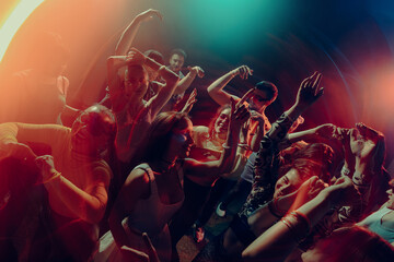 Naklejka premium Joyful crowd dancing under cinematic colorful lights. Concept of collective happiness, emotional expression, night freedom, music driven unity and New Year celebration mood.