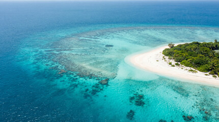 Fototapeta premium Aerial view of tropical island beach with turquoise lagoon and coral reef