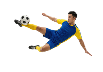Soccer player in blue yellow uniform kicking ball in mid air isolated
