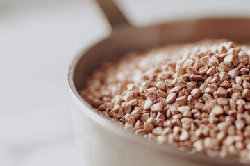 Close Up View of Buckwheat Grains in a Ceramic Pan on a White Surface with Natural Lighting