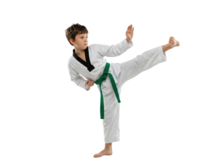Young boy practicing high kick in martial arts uniform on white background