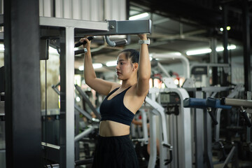 Woman training back on a pull-up machine in a gym, showing strength, focus, and an active lifestyle.