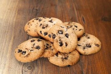 Tasty sweet chocolate chip cookies on desk