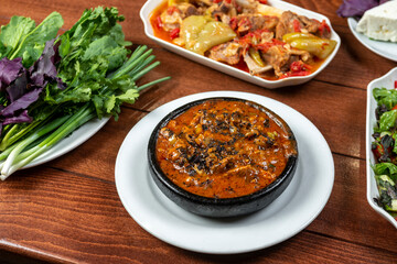 Thai spicy chili sauce with pork in black bowl on wooden table
