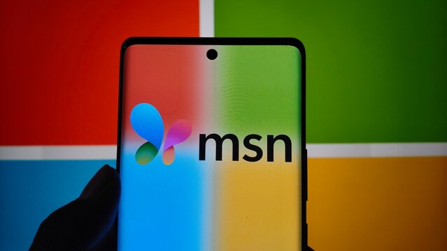 Msn logo displayed on a modern smartphone screen against a blurred microsoft background