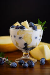Dessert parfait of yogurt melon and blueberries on a wooden