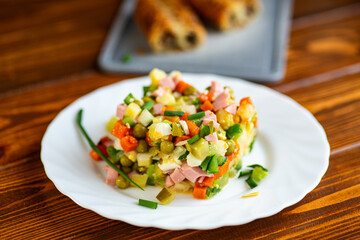 Classic olivier salad served fresh on white plate