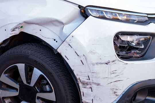 Fototapeta heavily wrecked car close-up, severely damaged car bumper and hood after major accident, Huge dent in car body, reckless driving, tire intact insurance case, repairs needed after serious collision