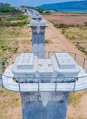 The concrete pillars/piers for the high-speed rail track are under construction at the unfinished construction site.