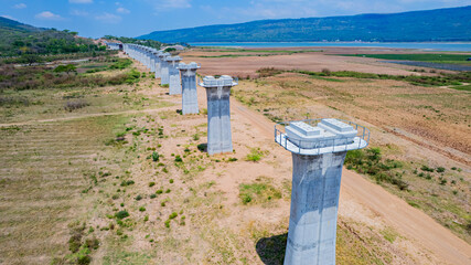 The concrete pillars/piers for the high-speed rail track are under construction at the unfinished construction site.