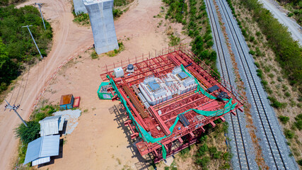 The concrete pillars/piers for the high-speed rail track are under construction at the unfinished construction site.