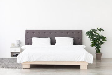 This spacious bedroom showcases a big comfortable double bed dressed in white linens. The...