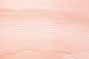 Cosmetic shimmering oil gel balm pink coral peach texture background. Beauty product sample swatch