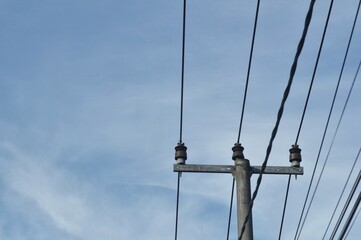 Utility Power Pole with Overhead Electrical Lines Against Blue Sky