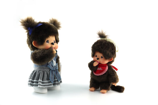 a popular classic doll toy , Monchichi or Monchhichi , Japanese cute monkey fur doll display on white table with white wall background in souvenir tourist shop in Japan