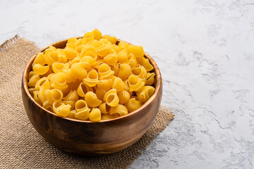 Raw pipe rigate pasta on stone table  background
