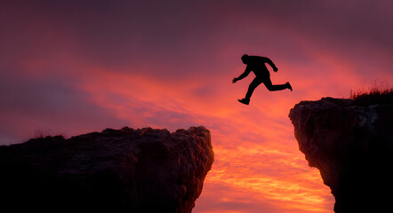 Silhouette of a man jumping across a dangerous cliff or chasm from the rock labeled 2025 to the rock labeled 2026 at a dramatic sunset