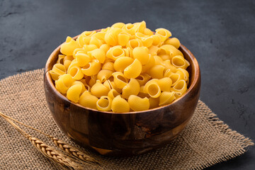 Raw pipe rigate pasta on black background