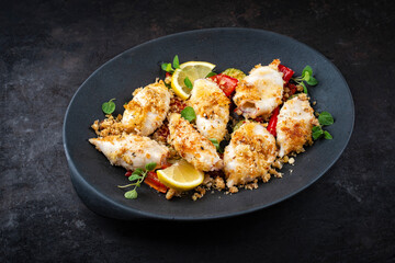 Traditional barbecue Greek calamari with herb and lemon served as top view on a design plate