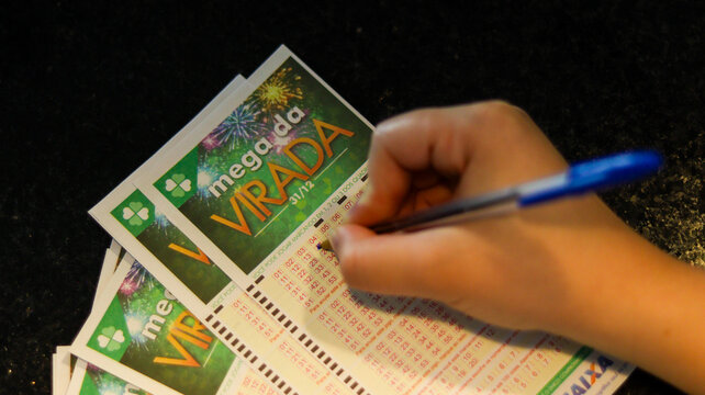 Pessoa anotando n&uacute;meros na cartela da Mega Sena da Virada representa concentra&ccedil;&atilde;o, estrat&eacute;gia pessoal e a esperan&ccedil;a de ganhar o pr&ecirc;mio milion&aacute;rio no sorteio de fim de ano. Suzano SP em 12 dez 25