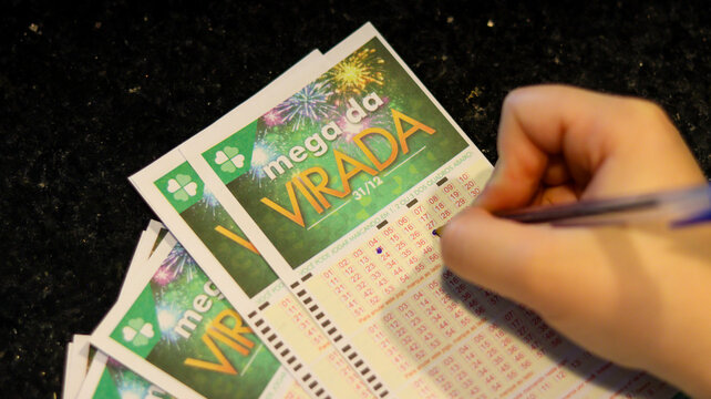 Cartela da Mega-Sena da Virada com n&uacute;meros sendo escolhidos manualmente, representando expectativa, sorte e tradi&ccedil;&atilde;o da loteria brasileira no sorteio especial de fim de ano. S&atilde;o Paulo em 10 dez 2025