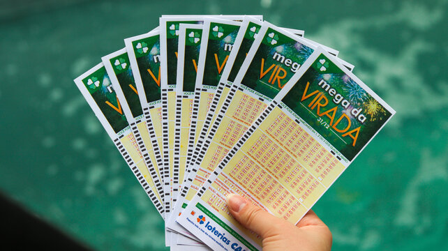 Pessoa segurando v&aacute;rias cartelas da Mega Sena da Virada, representando m&uacute;ltiplas apostas, esperan&ccedil;a coletiva e a busca pelo pr&ecirc;mio milion&aacute;rio. S&atilde;o Paulo SP em 12 dez 25.