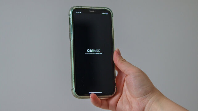 Aplicativo C6 aberto em smartphone representa servi&ccedil;os p&uacute;blicos digitais e acesso governamental online. S&atilde;o Paulo SP em 10 Abril 26.