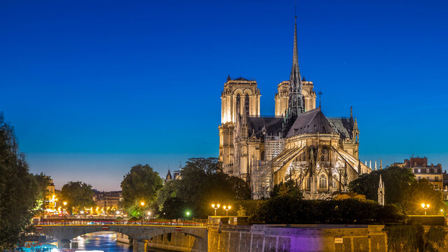 Rear view of Notre Dame De Paris cathedral day to night timelapse after sunset.