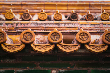 View of ornate golden roof tiles adorned with circular dragon emblems, reflecting ancient craftsmanship and imperial grandeur, Beijing, Beijing, China.