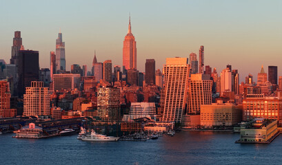 Fototapeta premium New York City aerial view of Midtown Manhattan skyscrapers illuminated by warm rays of sunset. Chelsea waterfront and Hudson River