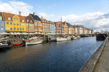 Copenhagen, Denmark - 30 September 2025: View of Nyhavn's vibrant facades reflecting in the canal's dark waters, a medley of colorful buildings meeting the serene waterway.