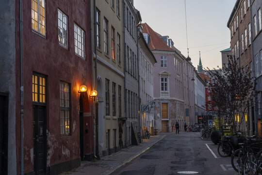 Copenhagen, Denmark - 30 September 2025: View of a quiet street with aged buildings in varied pastel shades under an even sky.