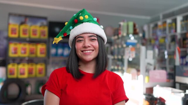 Happy young woman dancing with a christmas hat in a car parts store during the holiday season