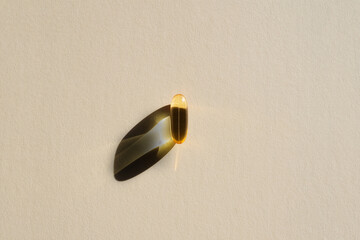 Fish oil capsule on a beige background. Medical concept.