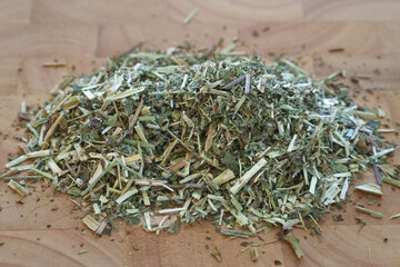 A Close-Up of Dried Meadowsweet Herb Displayed on a Wooden Surface, Emphasizing Its Unique Color, Texture, and Preparing for Herbal Applications