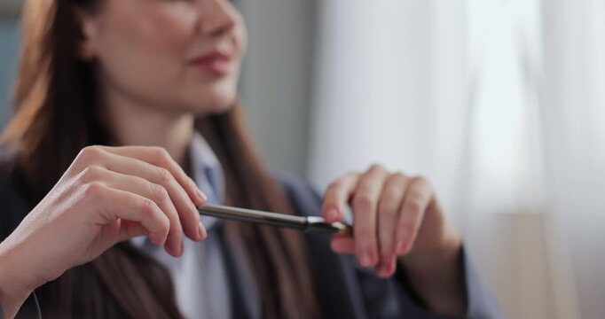 Woman psychologist sits in office and listens attentively, holds pen and notebook. Therapist on therapy session.