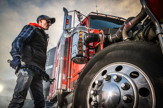 Man Working on a Red Semi Truck in an Outdoor Location