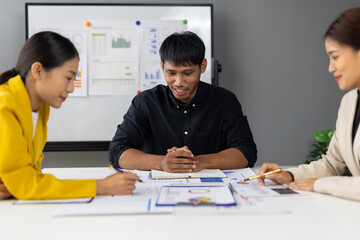 Asian businesspeople having a meeting and working together analyzing financial reports, planning business development strategy and discussing investment risk management.