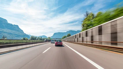 Fototapete Alpen Driving on a highway through the mountains and meadows in Italy timelapse hyperlapse drivelapse  © HyperlapsePro