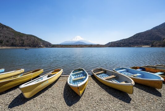 Rowing boats on shore, view across the lake to Mt Fuji volcano, Motosu Lake, Yamanashi Prefecture, Japan